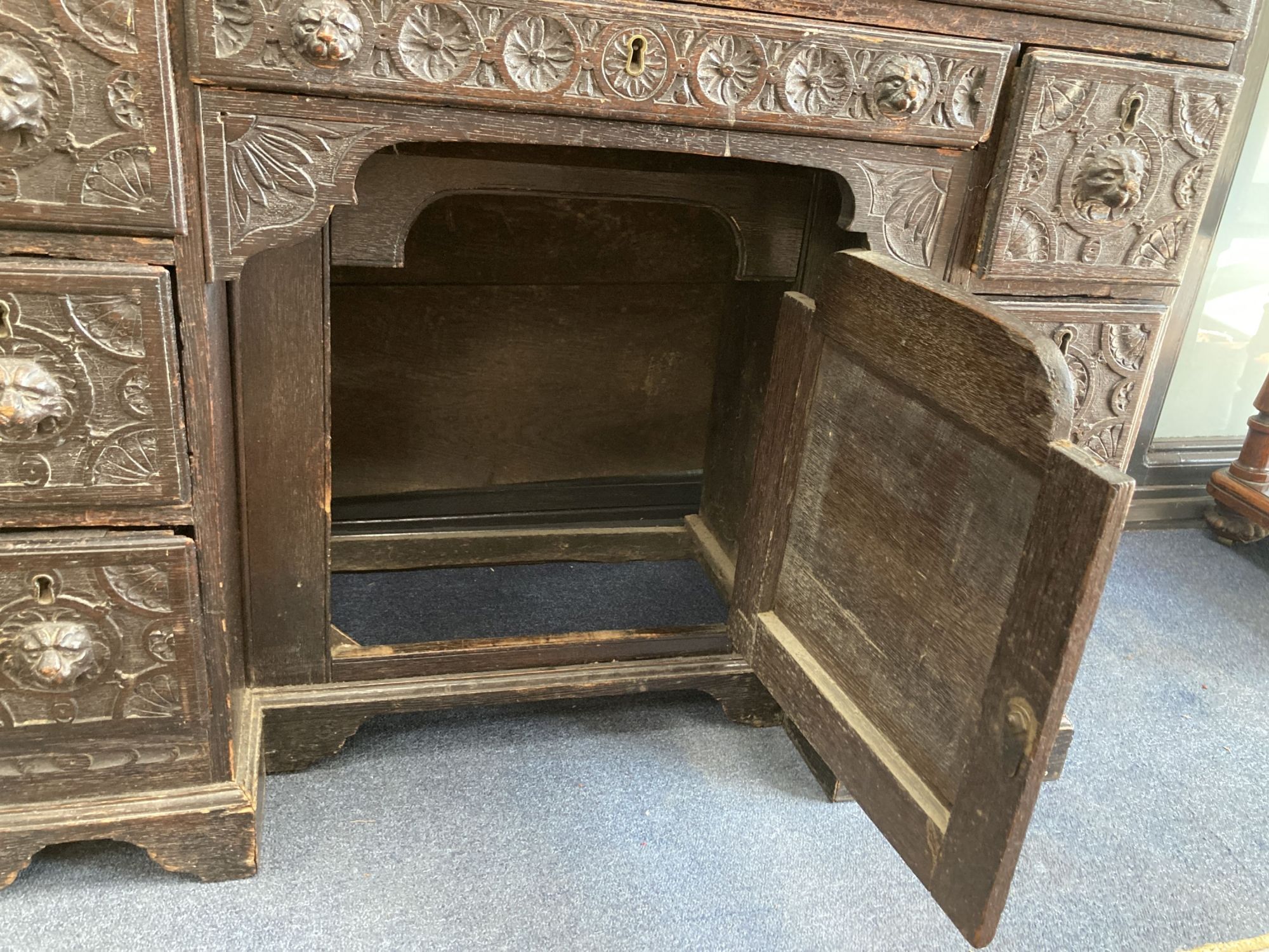 A late 19th century carved oak kneehole desk, length 94cm, depth 48cm, height 82cm